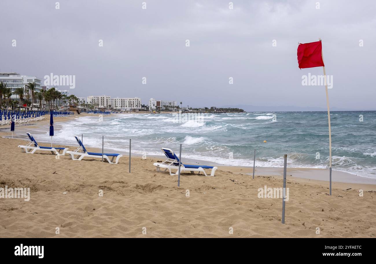 Bandiera rossa sulla spiaggia tempestosa. Pericoloso per il nuoto. Baia di fico Protaras Cipro Foto Stock