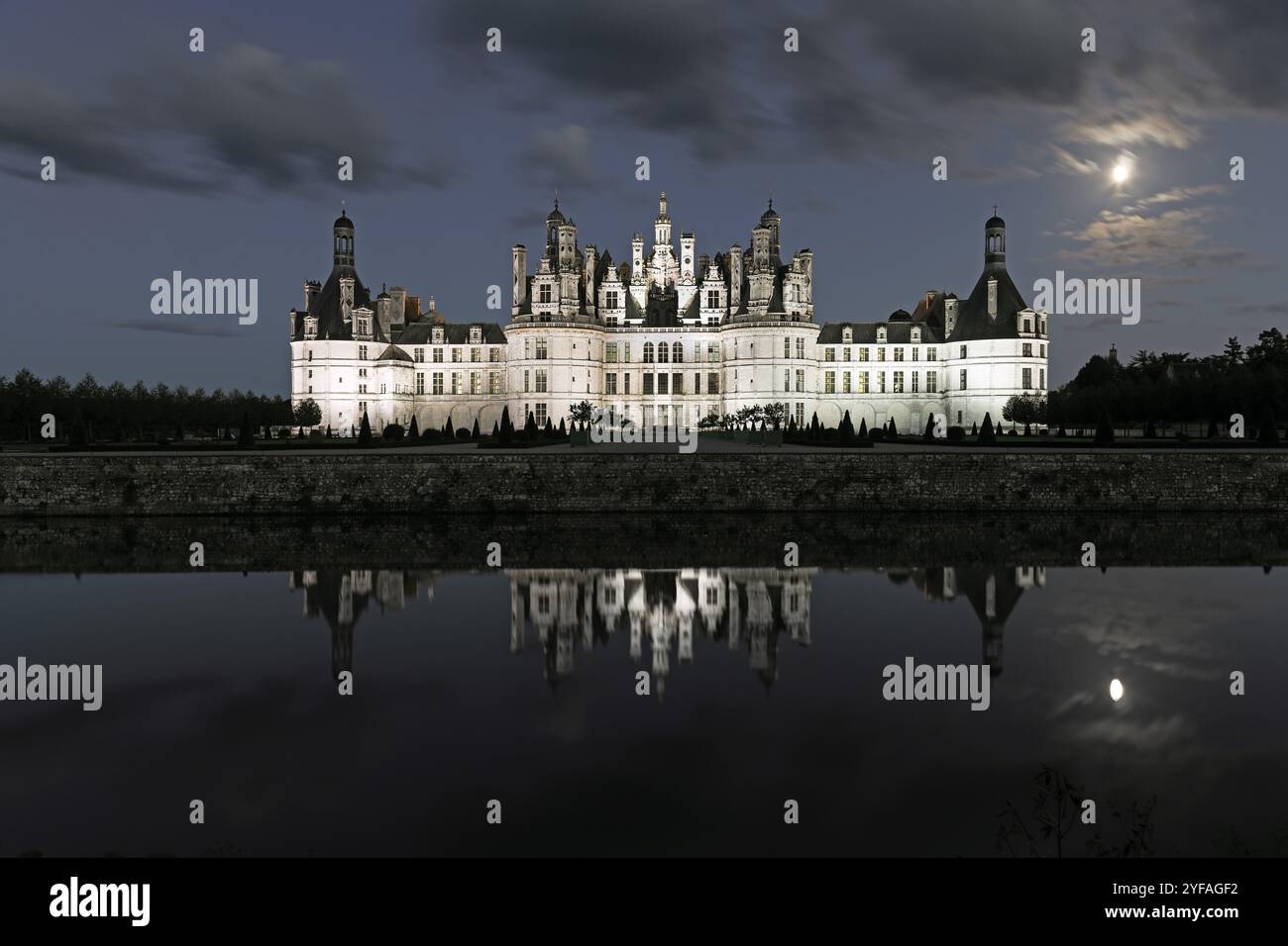 Chateau de Chambord illuminato di notte e riflesso nel fiume Cosson, Loira, Francia Foto Stock