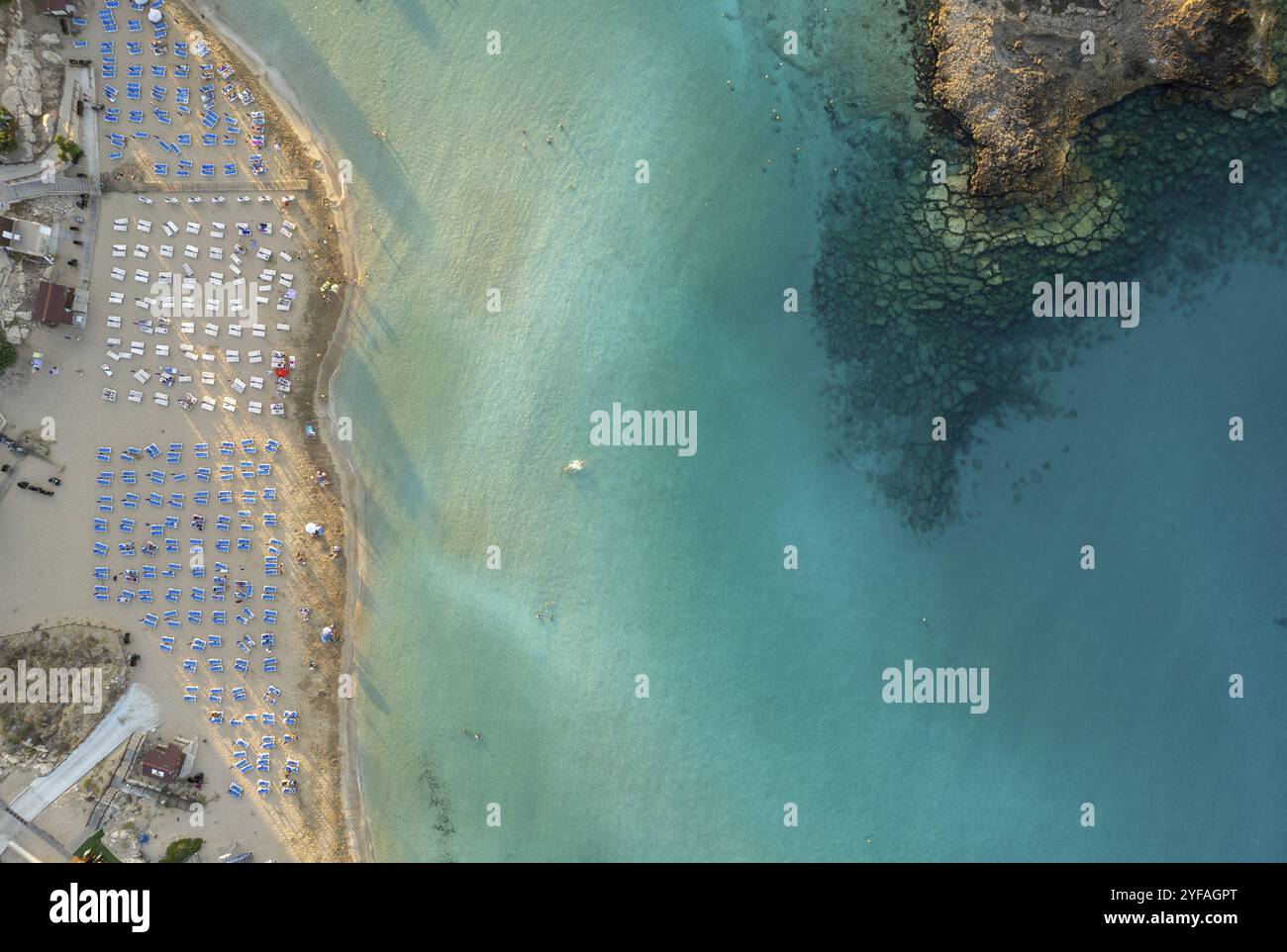 Ombrelloni in fila presso la spiaggia di fichi baie Protaras Cipro. Vacanze estive resort vacanze sabbia dorata Foto Stock