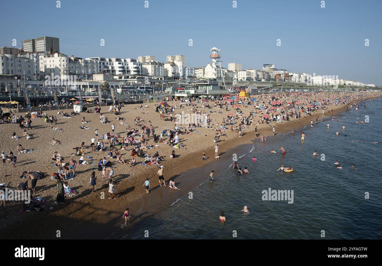 Brighton, Regno Unito, 10 giugno 2023: Folla di cittadini britannici che prendono il sole nuotano e si rilassano in spiaggia in estate. Tempo libero all'aperto, Europa Foto Stock