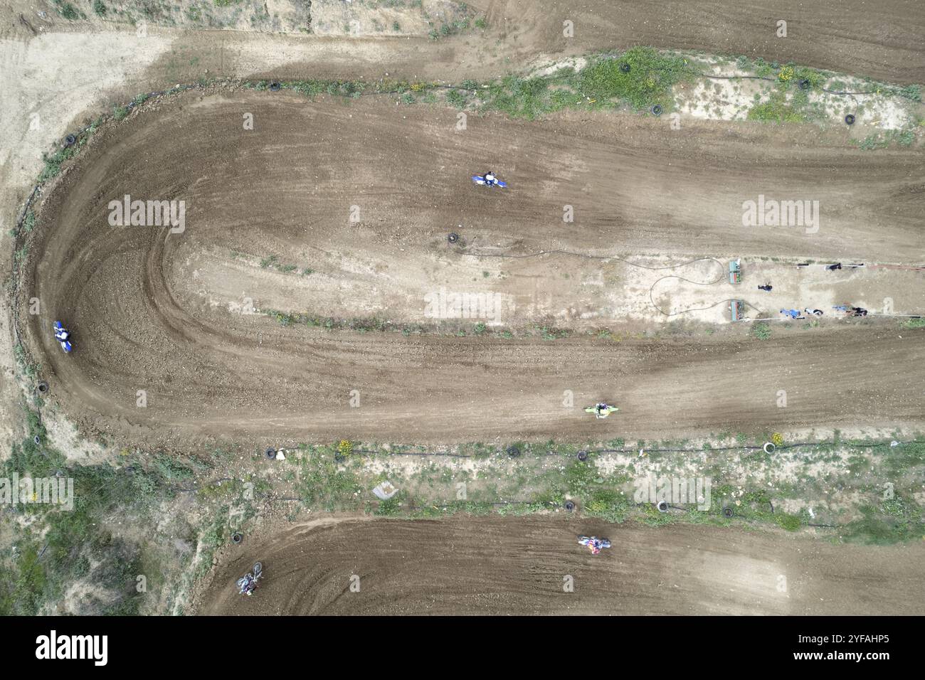 Drone aereo di una gara di motocross su una pista sportiva sterrata e sinuosa. Vista aerea delle corse ad alta velocità. Atleti in azione Foto Stock