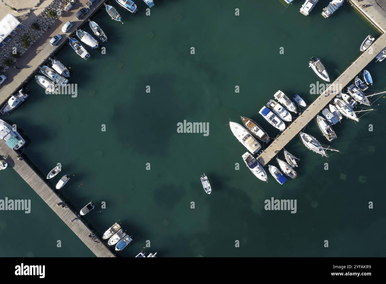 Drone scenario aereo di un porto di pesca. Barche da pesca e yacht ormeggiati nel porto. Zygi porto turistico Cipro Foto Stock