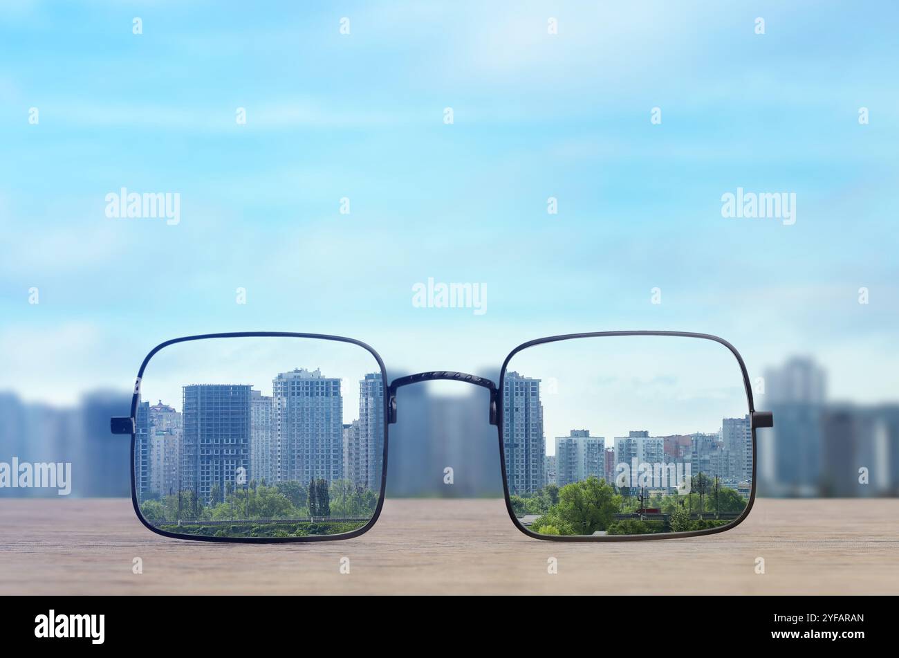 Occhiali contro il paesaggio urbano. Guarda attraverso gli obiettivi più nitidi. Correzione della visione Foto Stock