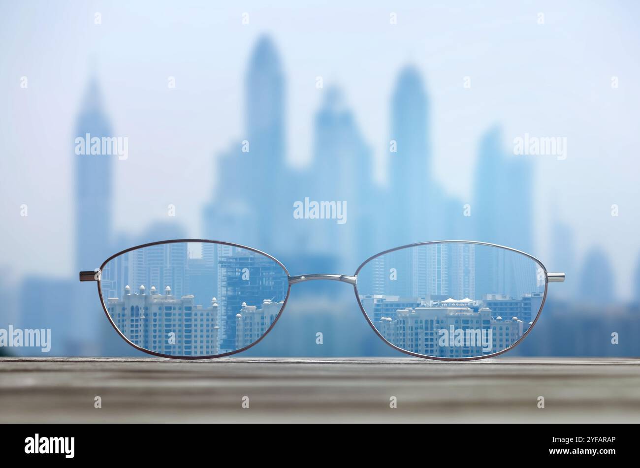 Occhiali contro il paesaggio urbano. Guarda attraverso gli obiettivi più nitidi. Correzione della visione Foto Stock