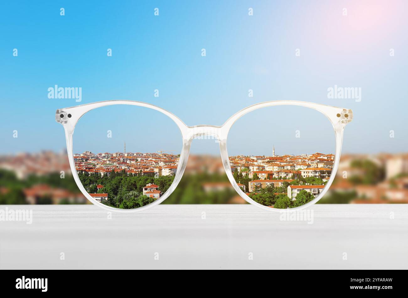 Occhiali contro il paesaggio urbano. Guarda attraverso gli obiettivi più nitidi. Correzione della visione Foto Stock