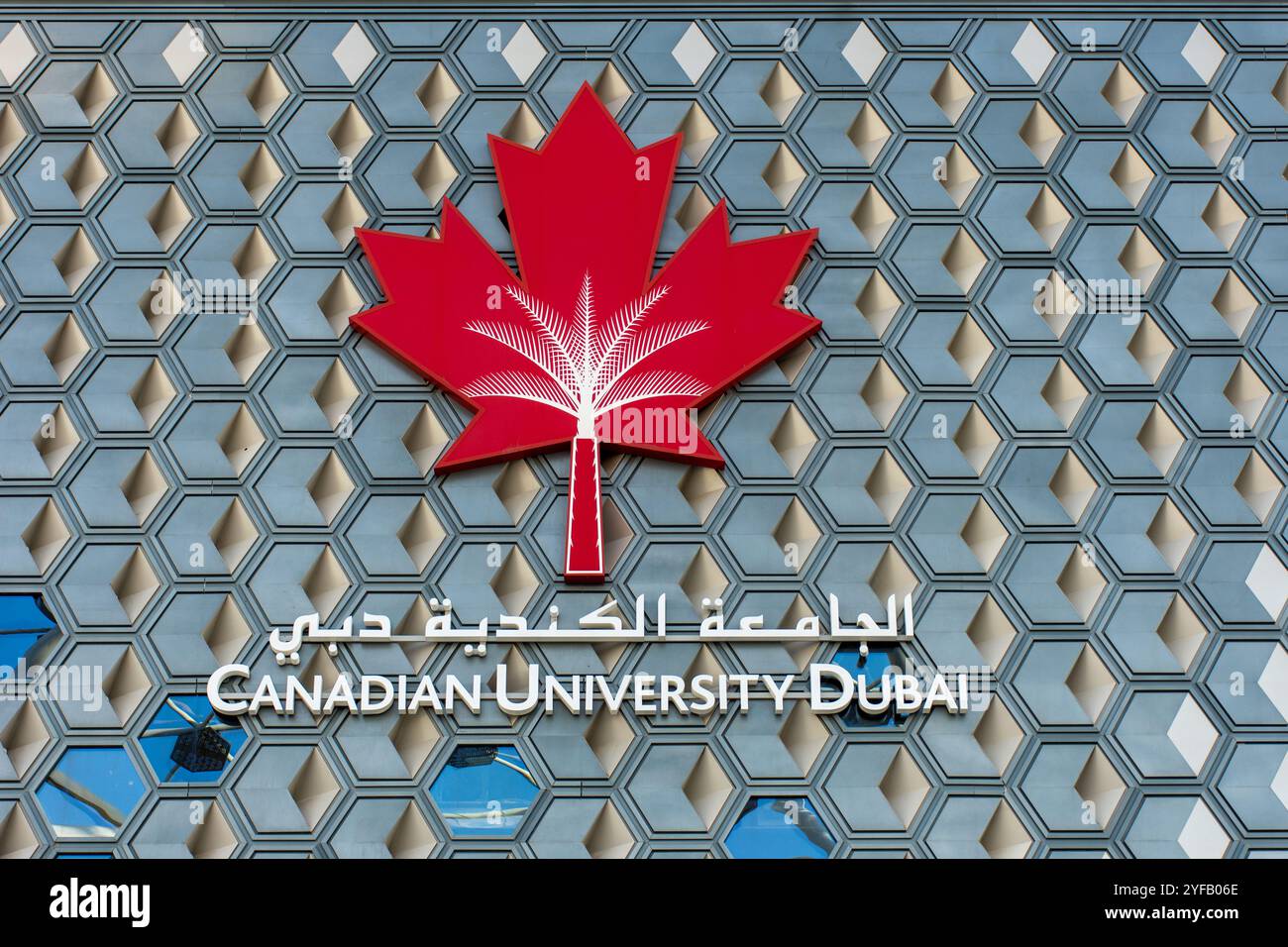 Logo e cartello della Canadian University Dubai su una moderna facciata edilizia a nido d'ape. Foto Stock