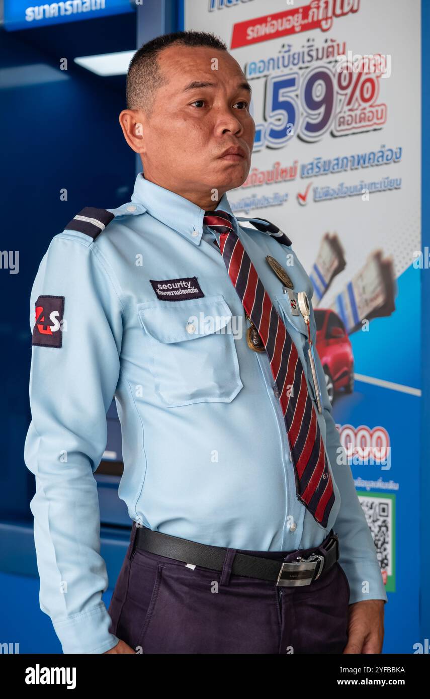 Guardia di sicurezza in servizio davanti alla porta della banca. Guardia di sicurezza all'ingresso della banca Phuket Thailandia. Una guardia in uniforme al Foto Stock