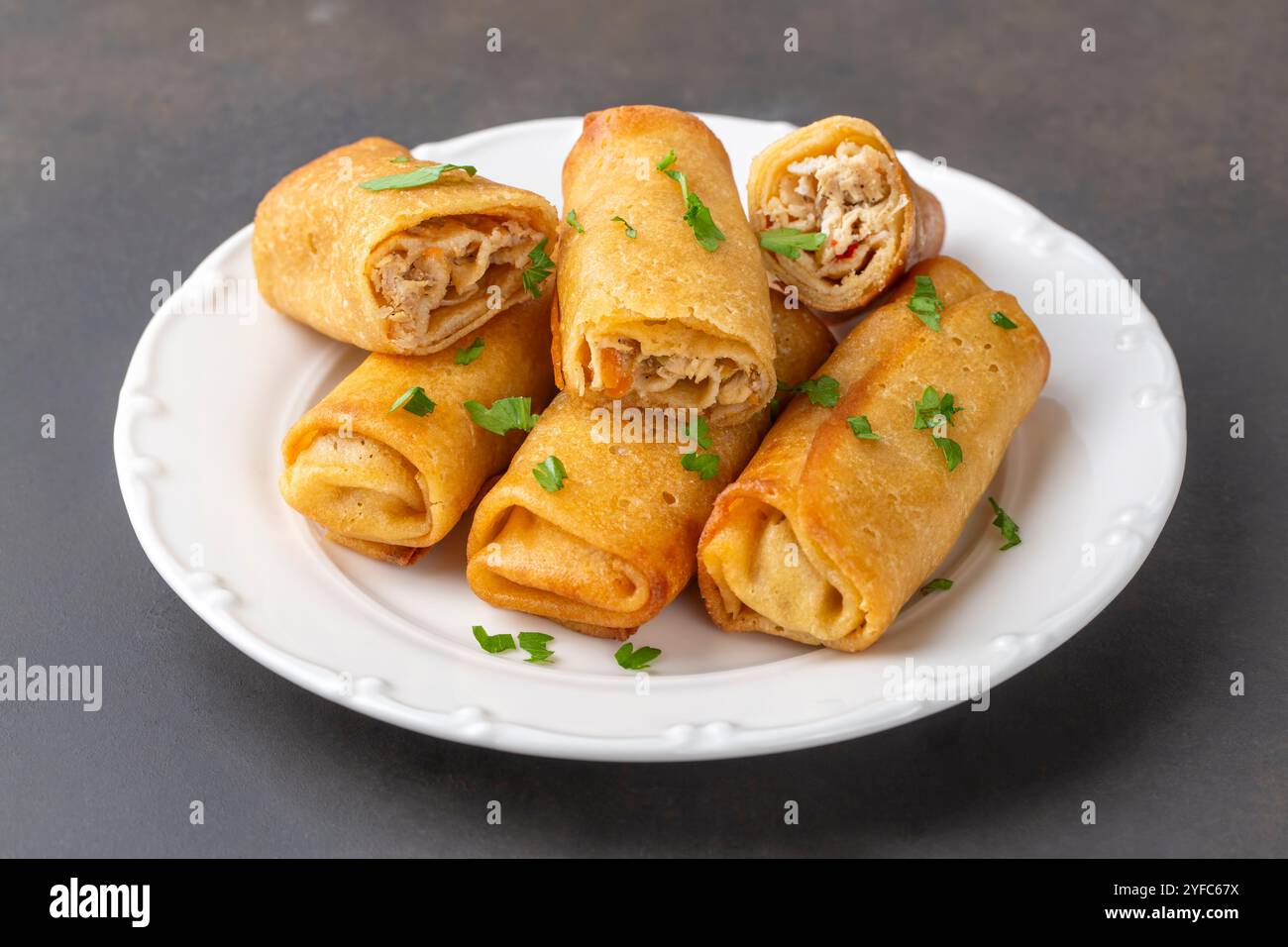 Frittelle o crepe sottili ripiene di pollo e funghi su un piatto Foto Stock