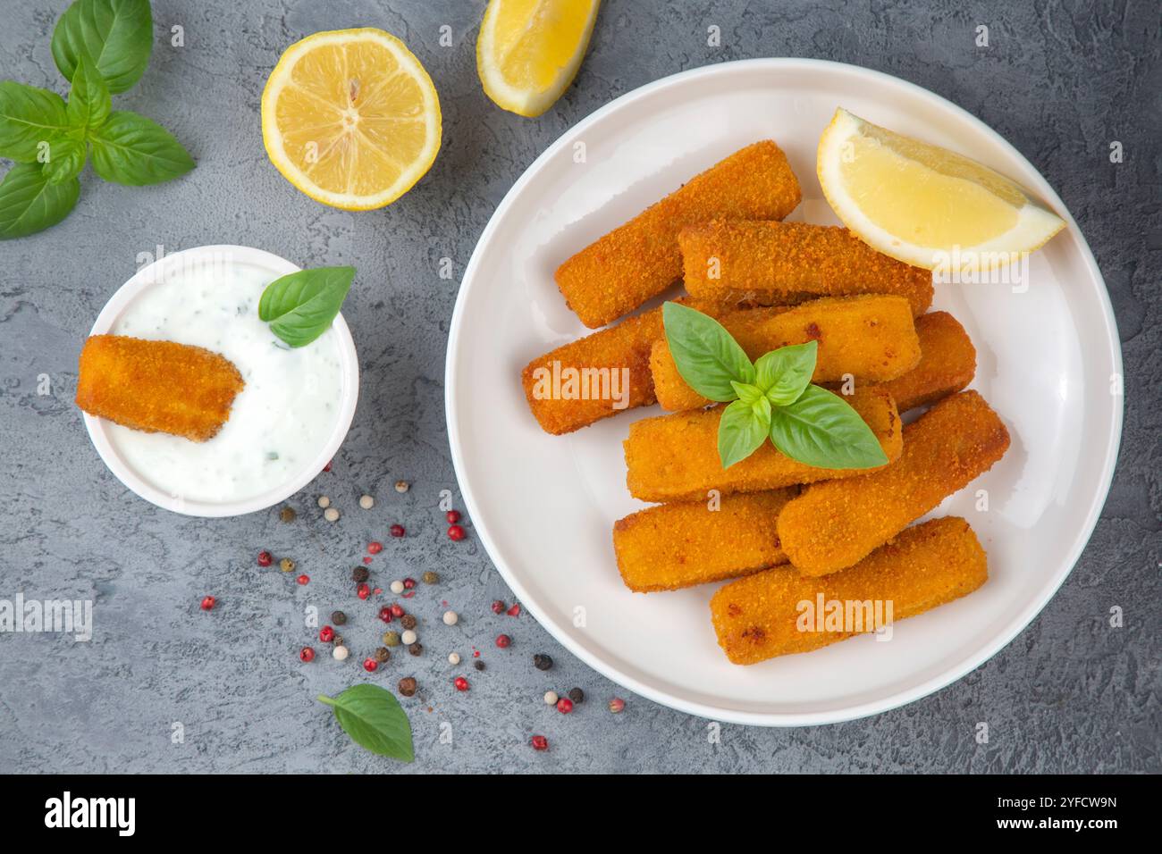 Fish and chips . Primo piano di bastoncini di pesce fritti e croccanti con pangrattato serviti con salsa remoulade e limone Foto Stock