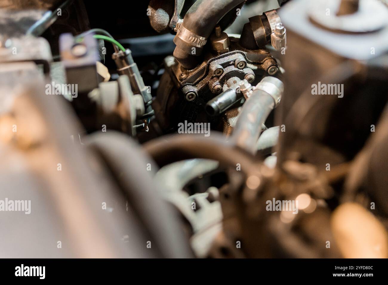 Primo piano di un componente del motore automobilistico in un ambiente di officina. Foto Stock