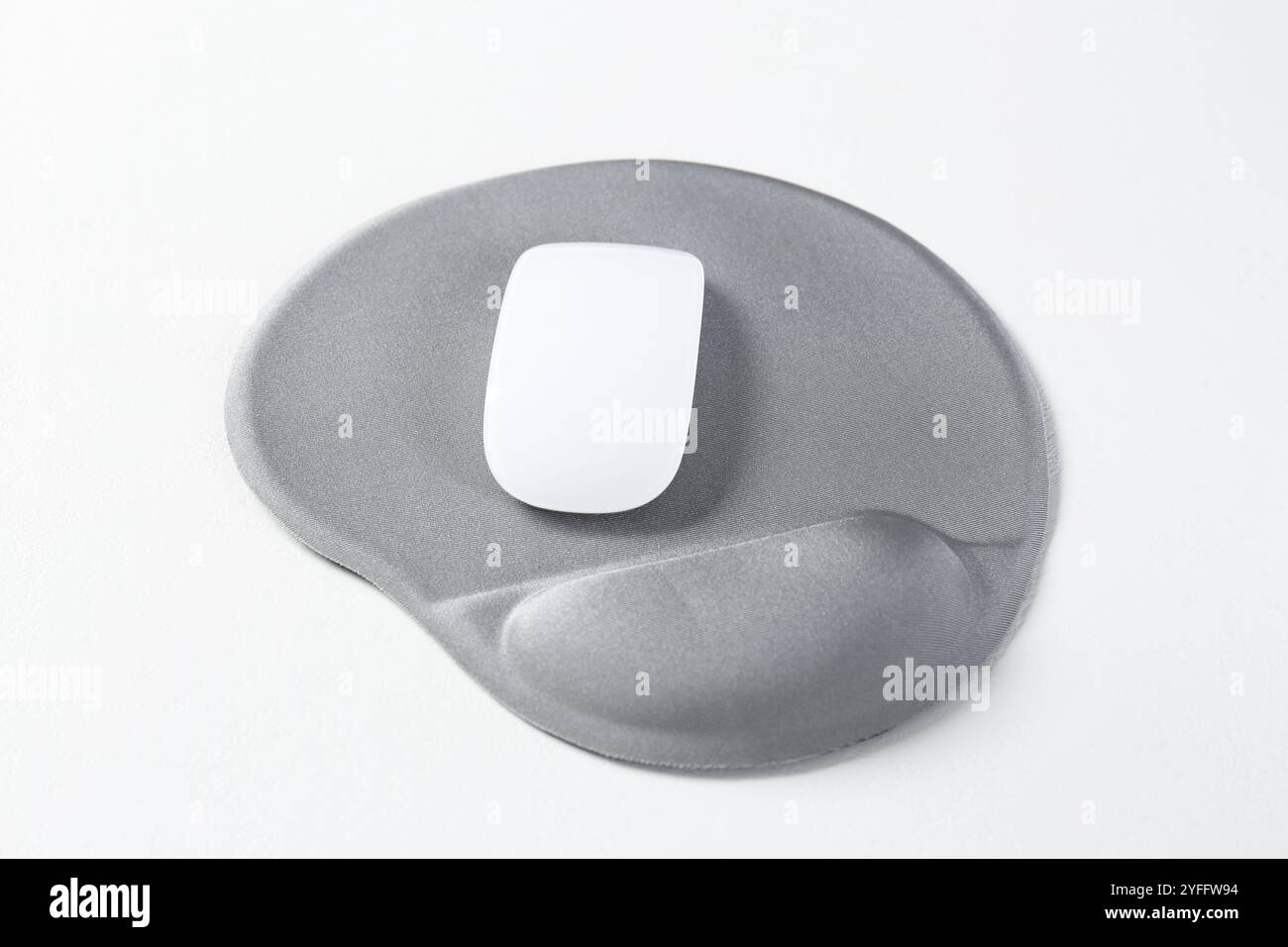 Mouse e tappetino con bracciolo su tavolo bianco, primo piano Foto Stock