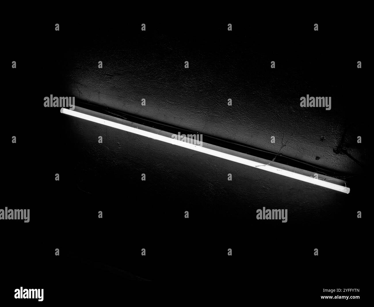 Lampada al neon da soffitto in un'atmosfera soffusa - contrasto bianco e nero Foto Stock