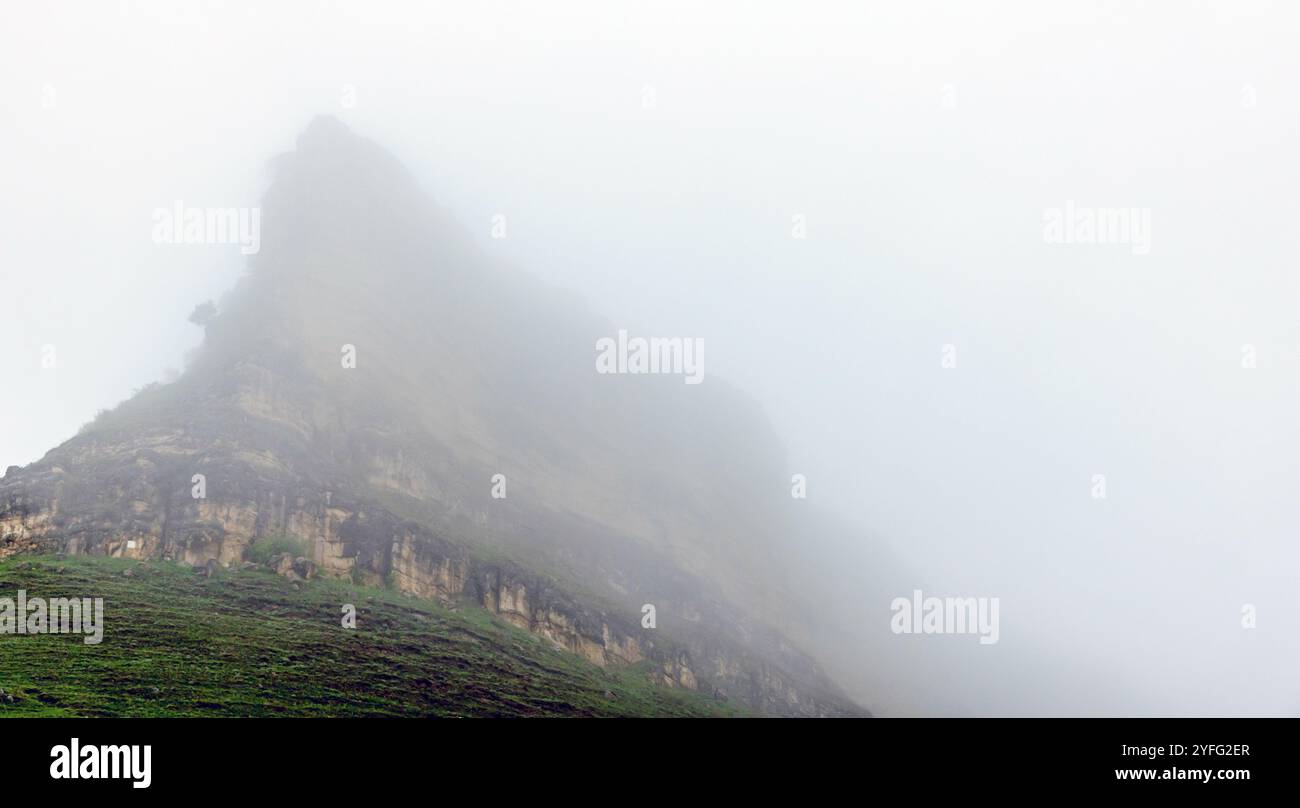 La vetta della montagna è sotto un cielo nuvoloso e luminoso in una giornata nebbiosa. Paesaggio naturale di Karachay-Cherkessia, Russia Foto Stock