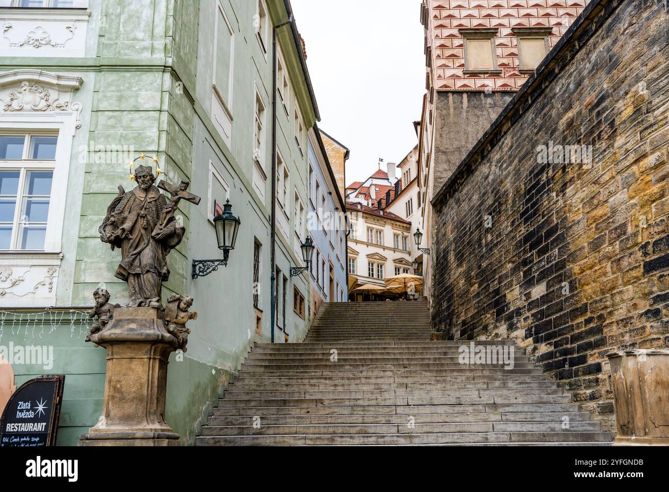 Statua in marmo del XVIII secolo di San Giovanni di Nepomuk di Ferdinand Maxmilián Brokoff all'inizio della scala scolastica Radnické, a Mala strana, Praga Foto Stock