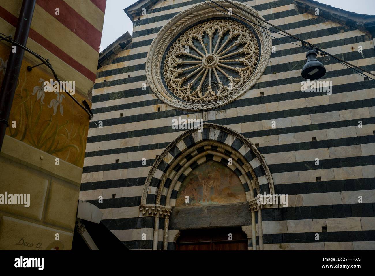 La Parrocchia di S. Giovanni Battista, chiesa del XIV secolo con facciata gotica a strisce di marmo bianco e nero e rosone, in Foto Stock