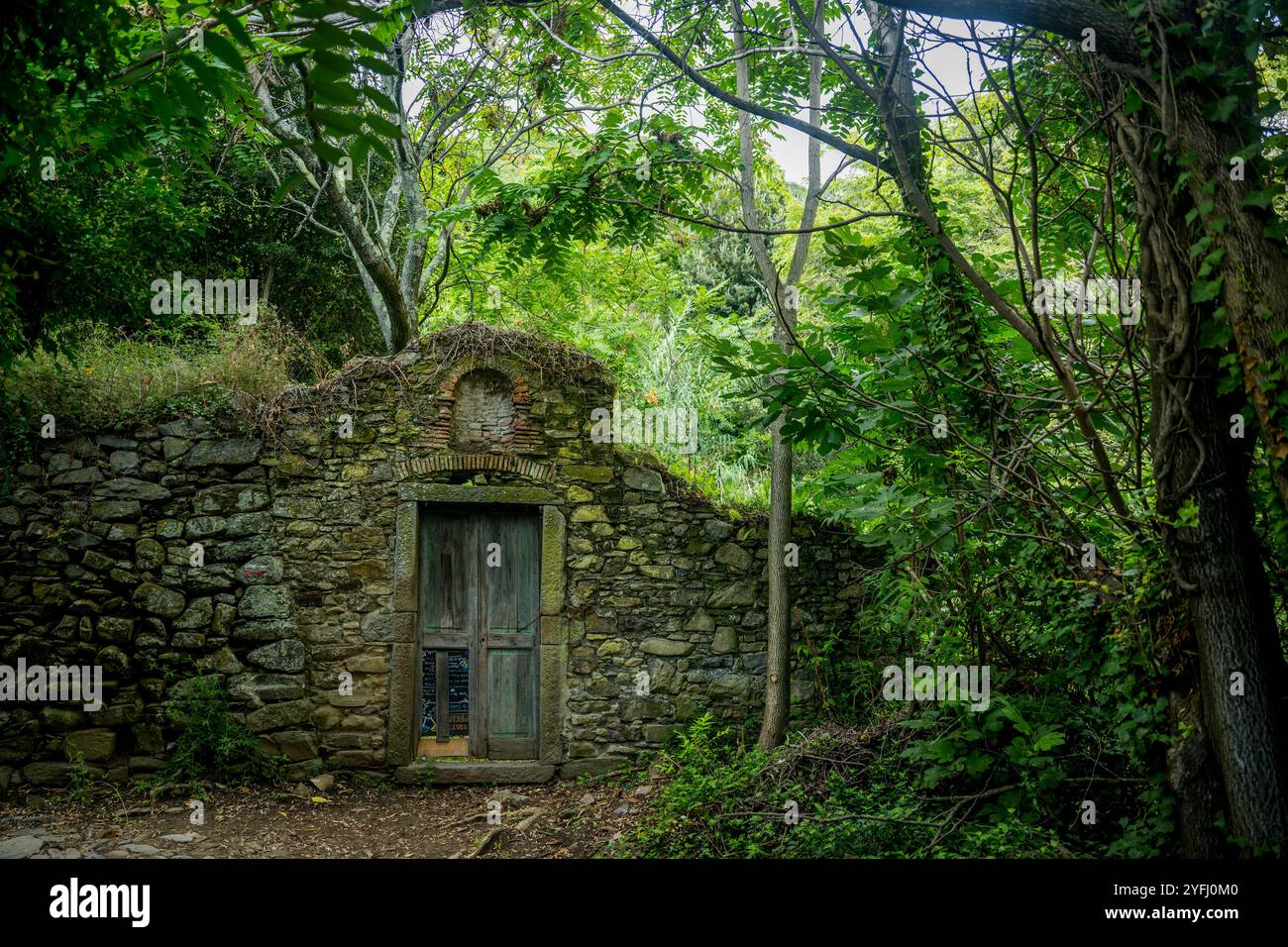 Un'antica cinta muraria e porta in pietra nei pressi di Vernazza lungo l'escursione da Corniglia a Vernazza, cinque Terre, provincia di la Spezia, parte della regione Liguria Foto Stock