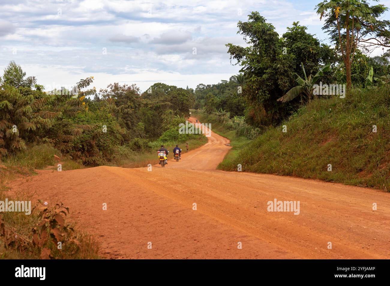 Motociclette su una tortuosa strada sterrata nell'Uganda rurale. Foto Stock
