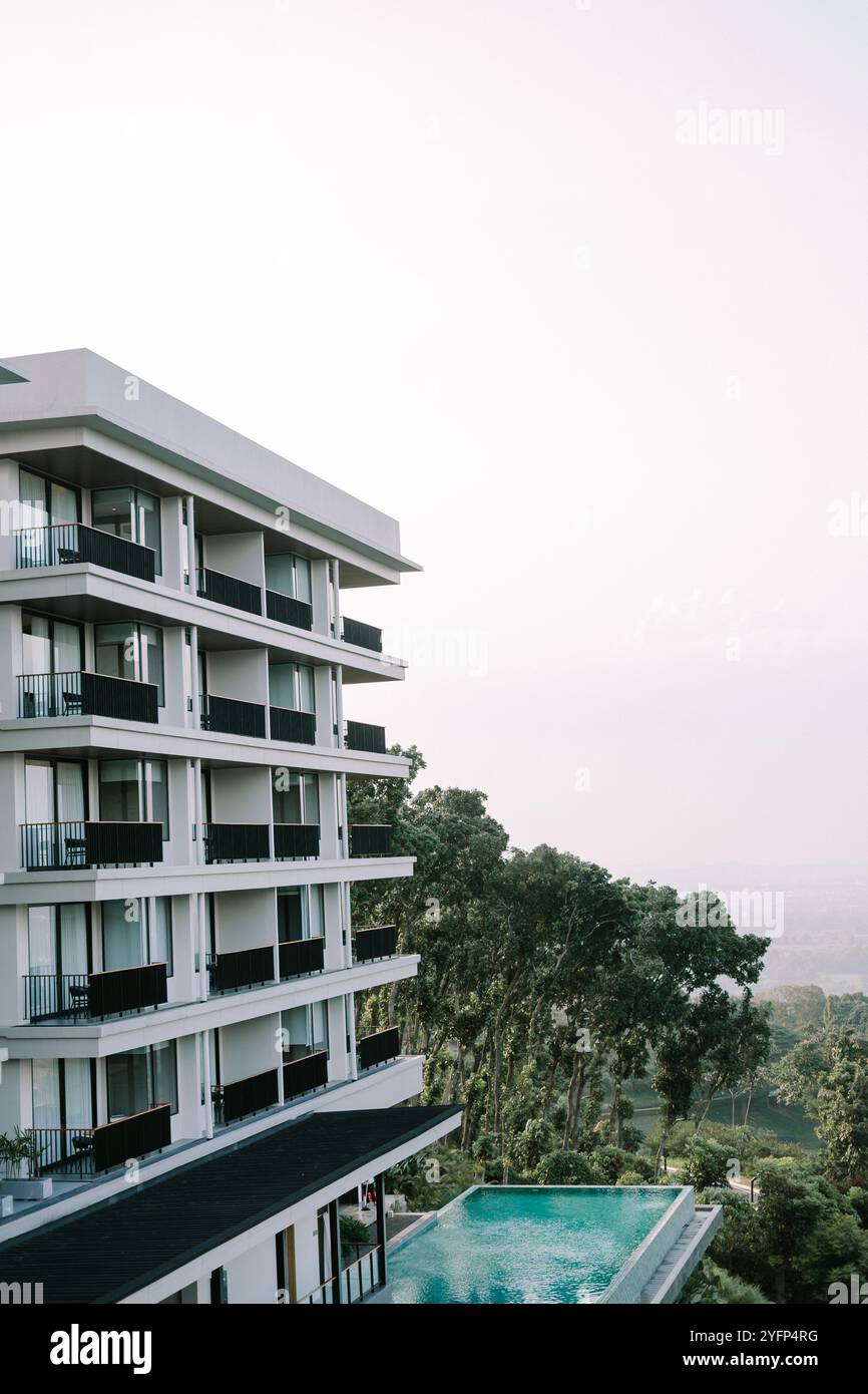 Lussuoso edificio alberghiero con un'elegante piscina, caratterizzato da un design moderno e un ambiente rilassante, che crea un ambiente perfetto per il tempo libero e il lavoro Foto Stock