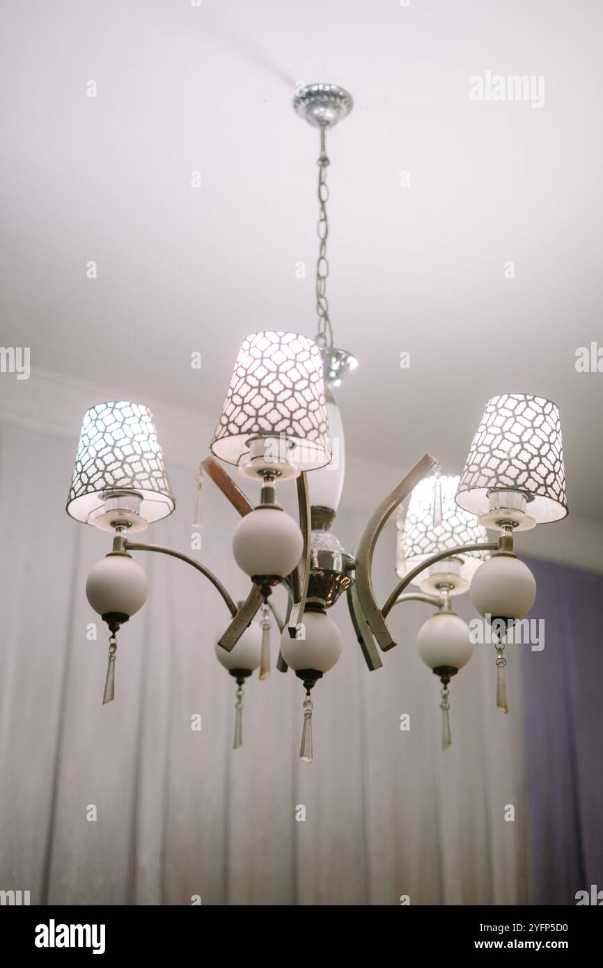 Elegante lampadario di lusso che illumina gli interni di una casa, aggiungendo un tocco di raffinatezza con un design complesso e un'illuminazione calda Foto Stock