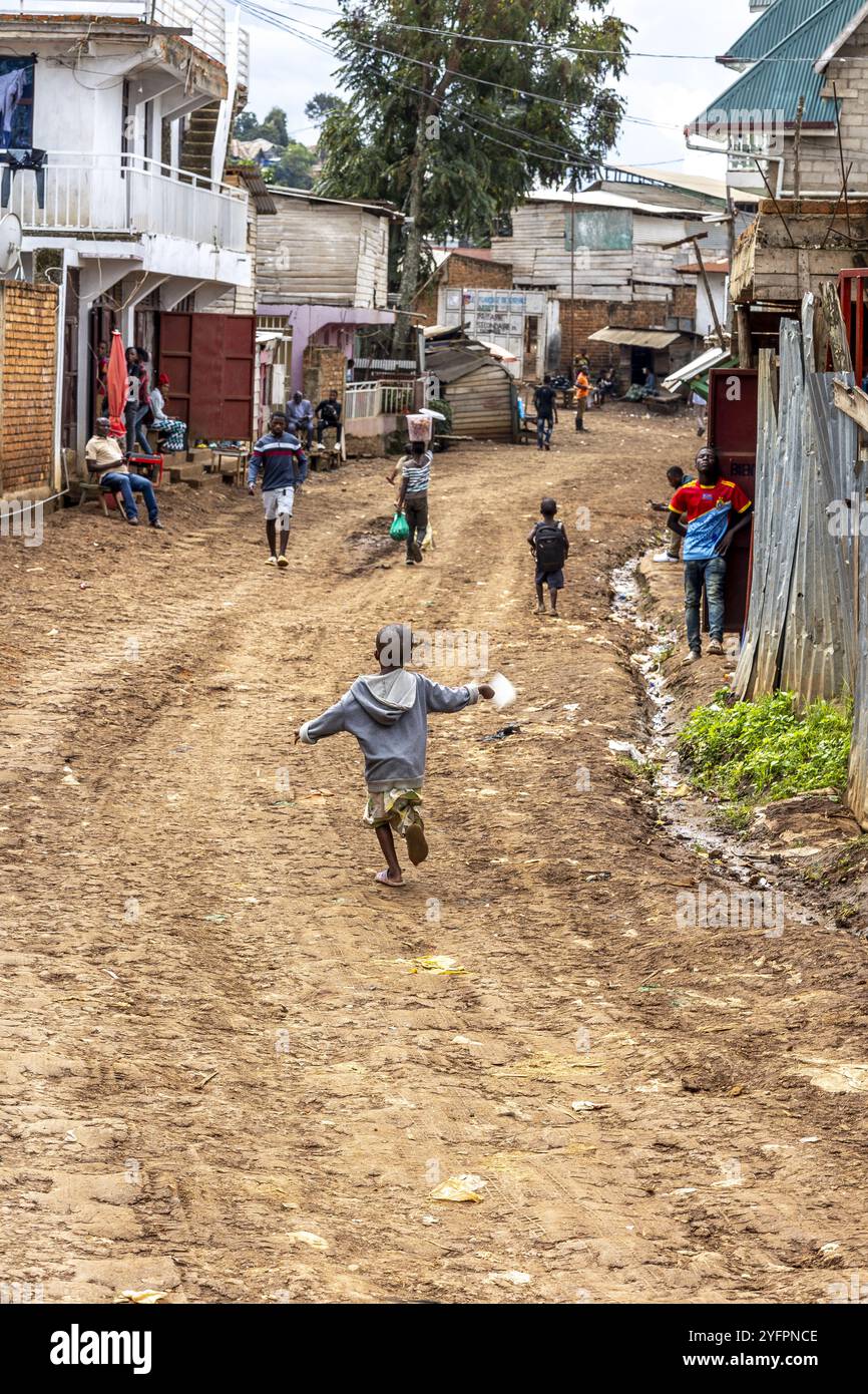 Bambino che corre con un aquilone fatto in casa in una strada di Bukavu, RDC Foto Stock