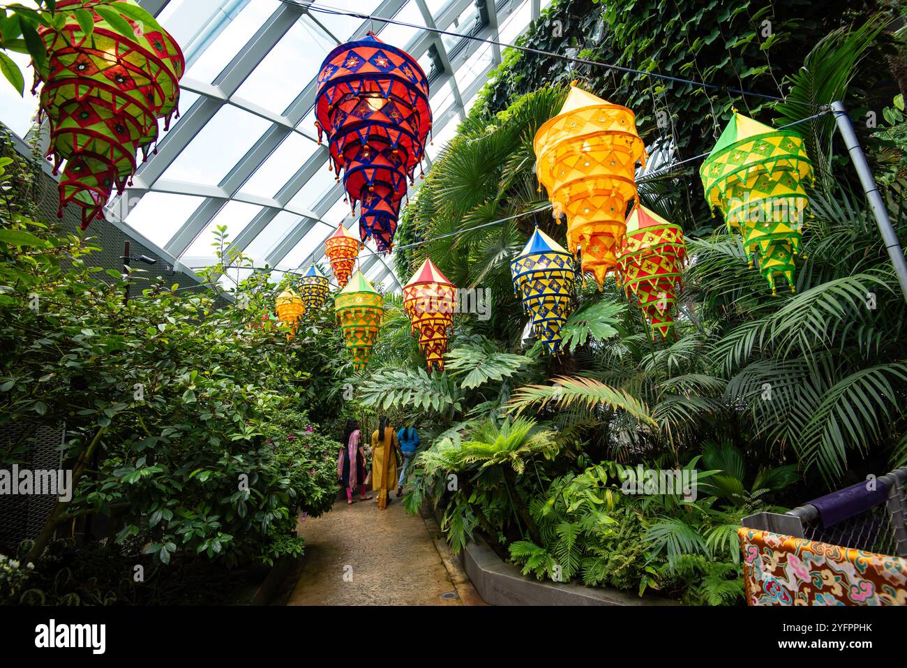 Persone che si godono la vista interna dei giardini e parte della cupola di vetro che copre il Cloud Forest Garden a Gardens by the Bay a Singapore Foto Stock