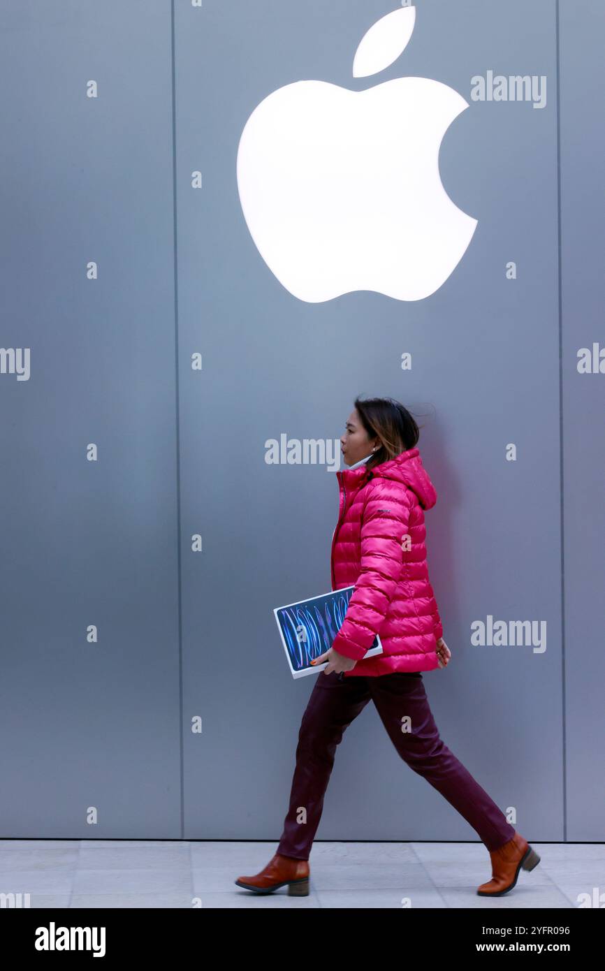 Esterno di un Apple Store con logo. Donna con nuovo iPad box; Francia. Foto Stock