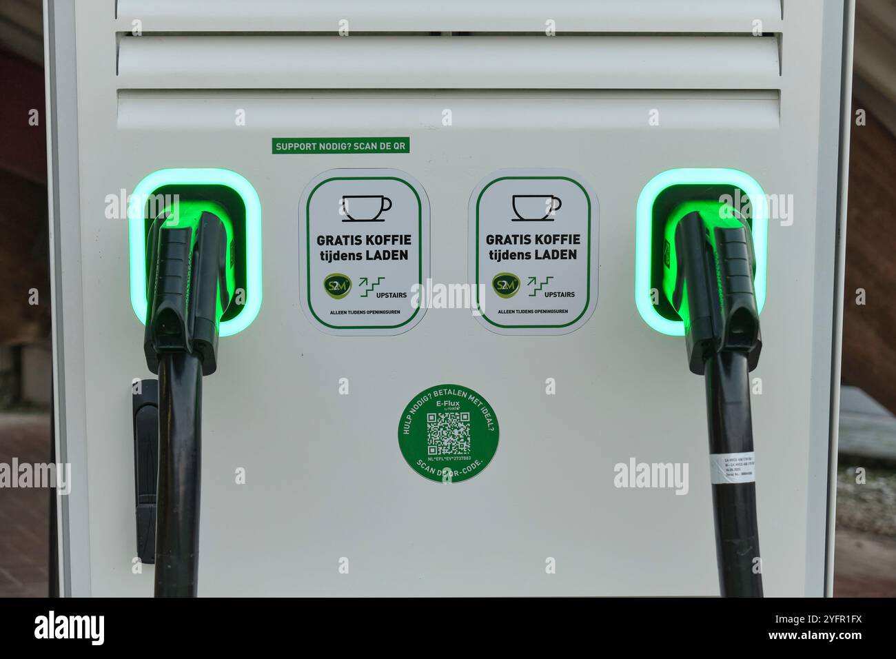 Energie rinnovabili nei Paesi Bassi: Primo piano di una stazione di ricarica per veicoli elettrici doppi con adesivi promozionali presso Green Planet. Foto Stock