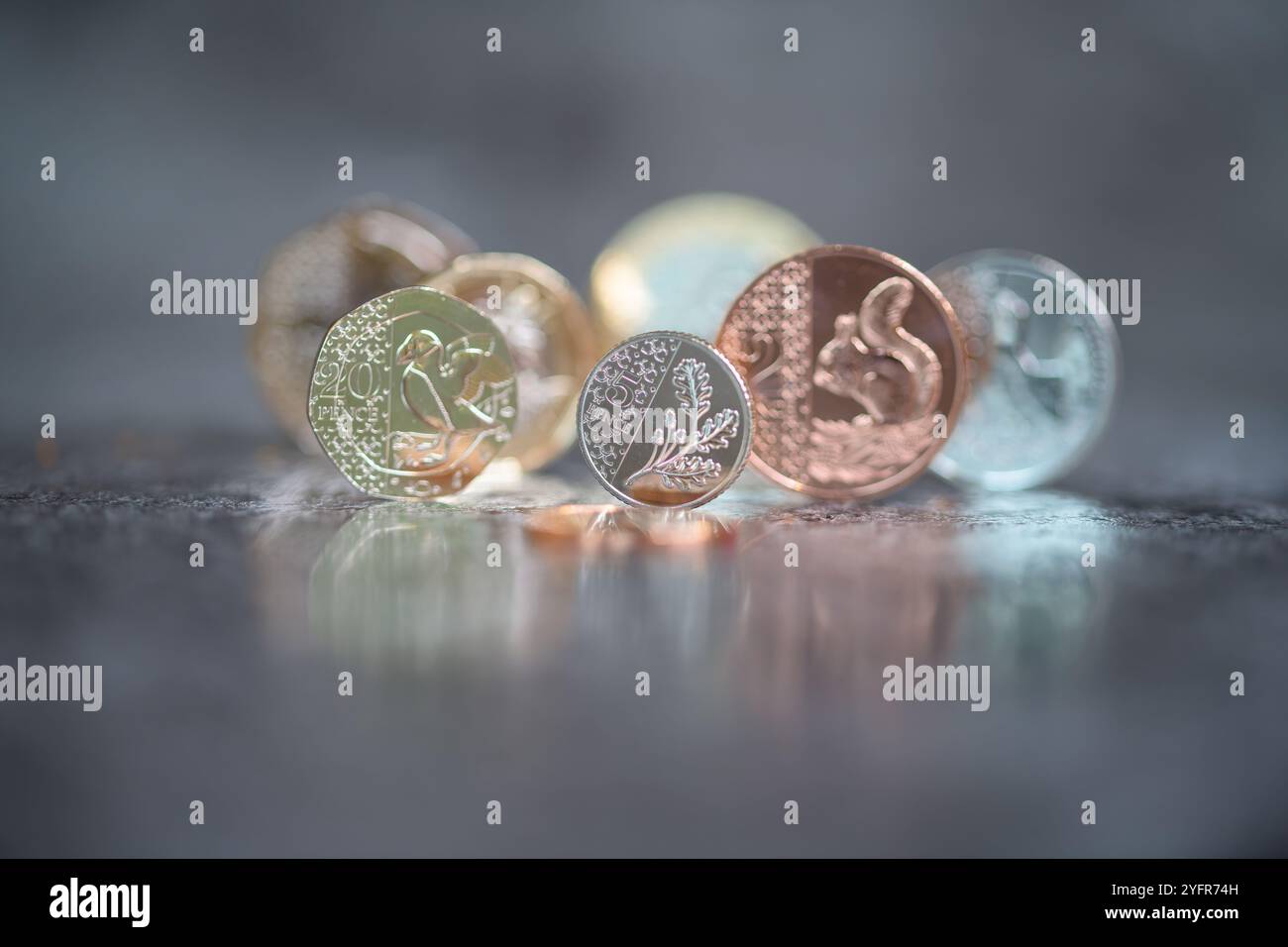 Sterling Coins, sua altezza reale Re Carlo III, in piedi su un top nero riflettente Foto Stock