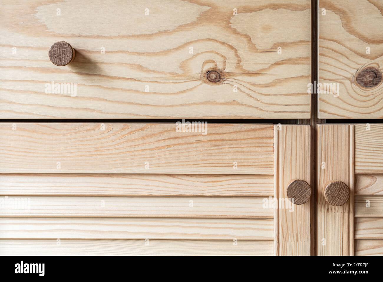 Porte con feritoie in legno con maniglie a pomello in legno per primo piano. Le porte a sfinestratura della cucina esterna sono realizzate in legno di pino chiaro con motivi a grana naturale Foto Stock