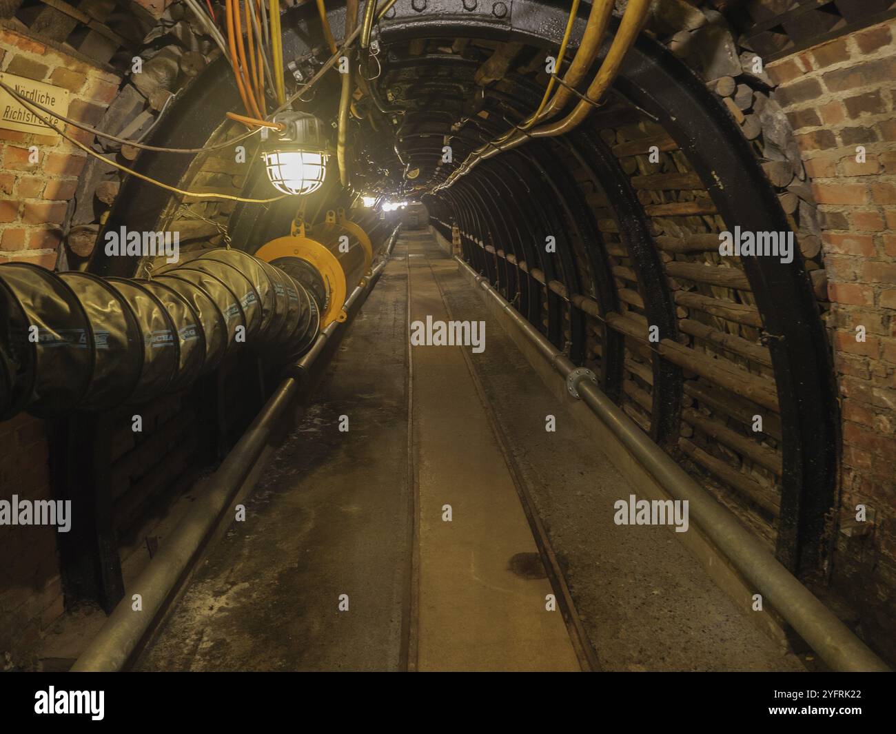 Tunnel industriale scuro con pareti in mattoni e illuminazione visibile, Bochum, Renania settentrionale-Vestfalia, Germania, Europa Foto Stock