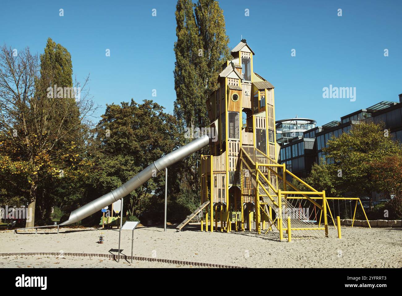 Moderno parco giochi per bambini per giochi all'aperto, scivolo in metallo, piramidi in legno, rivestimento in gomma sul parco giochi. Giochi per bambini Foto Stock