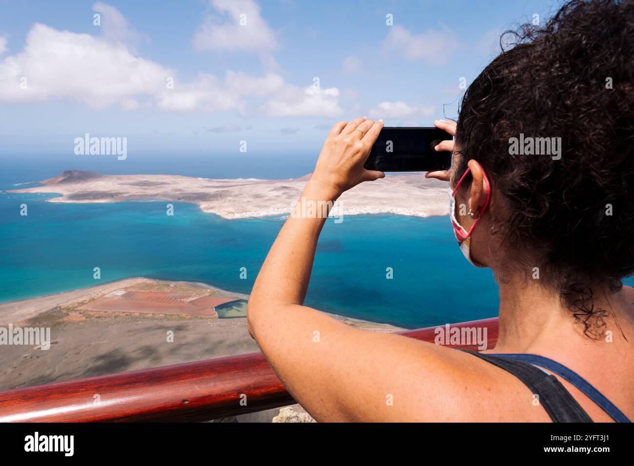 Vista posteriore di una turista che scatta foto dell'isola Foto Stock