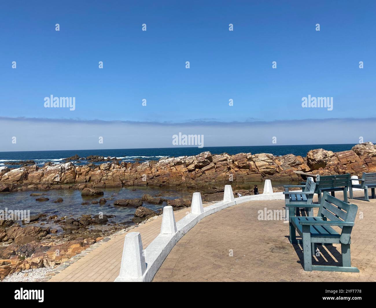 Passeggiando lungo il sentiero, con onde che si infrangono e rocce alte, dove la natura incontra la tranquillità. Siediti, respira la vista e rallenta Foto Stock