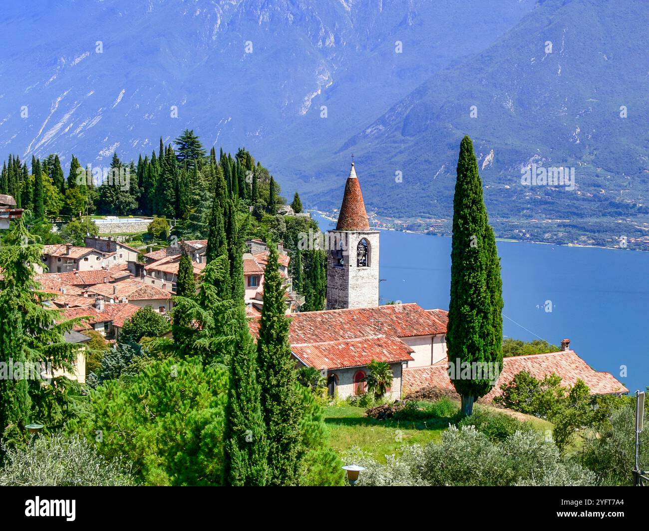 Veduta dei cipressi, della chiesa e delle case di Pieve. Pieve è il capoluogo del comune di Tremosine sulla sponda occidentale del Lago di Garda. Foto Stock