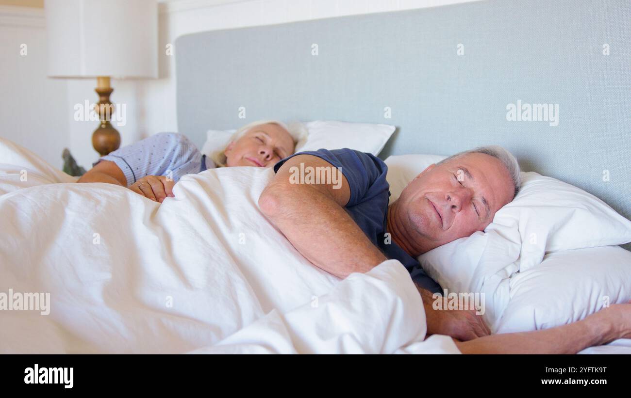 Tranquilla coppia senior che dorme nel letto a casa insieme Foto Stock