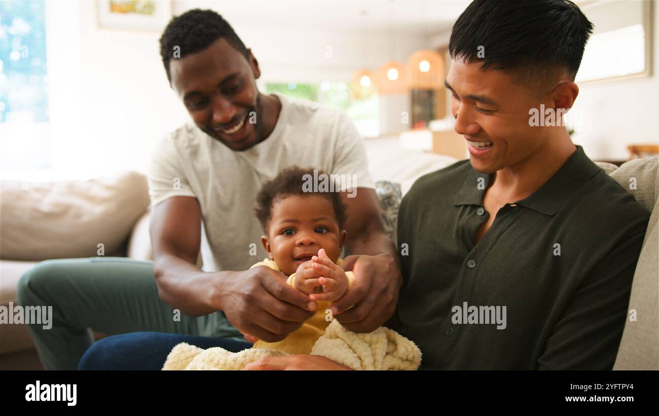 I padri si impegnano con gioia con il loro bambino in una casa calda e invitante. Foto Stock