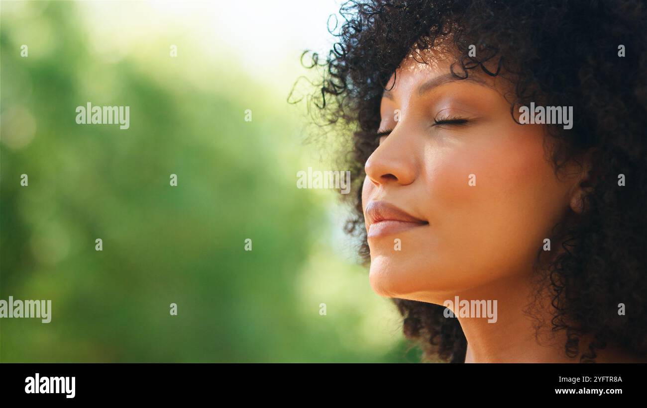 Una donna gode di una meditazione tranquilla in un'area verde all'aperto. Foto Stock