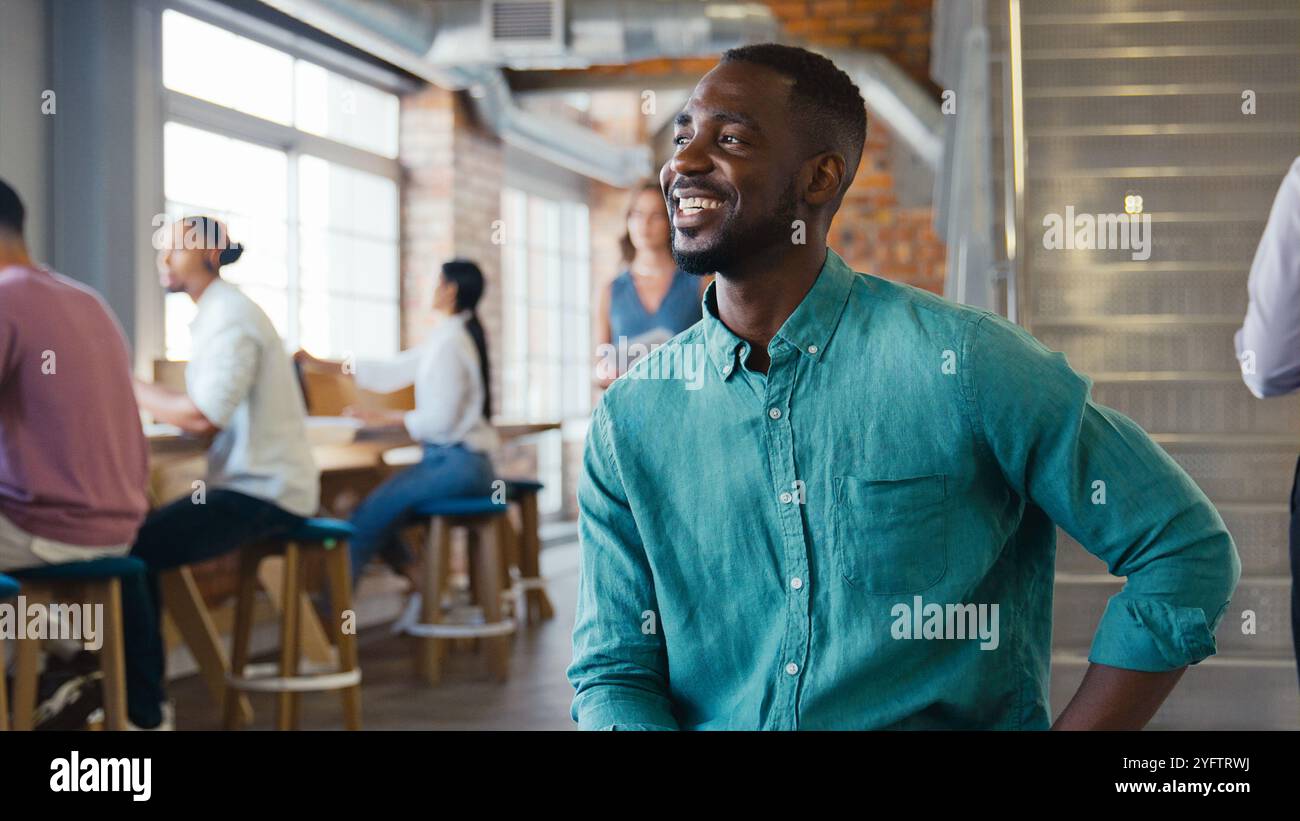 Uomo d'affari sorridente che lavora in un moderno ufficio open space Foto Stock