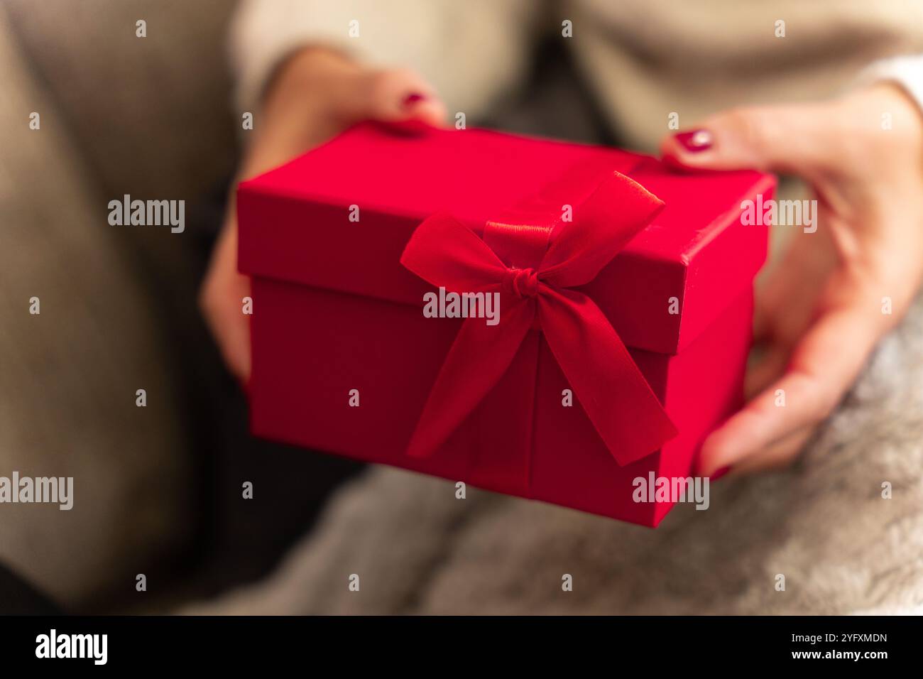 fare un regalo di natale in una scatola rossa con un fiocco Foto Stock
