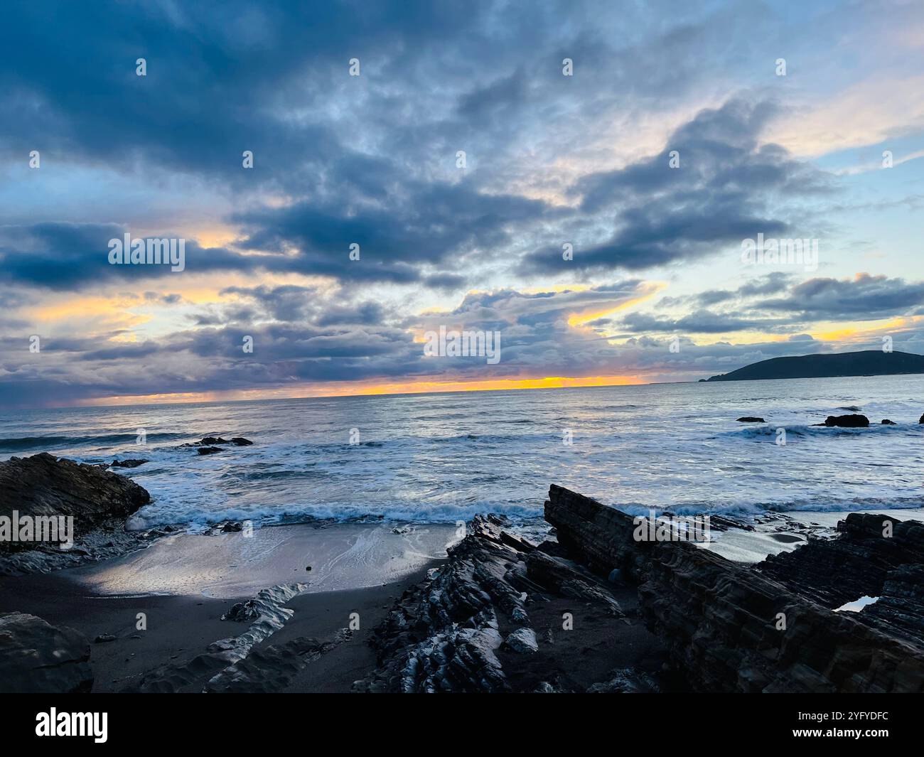Tramonti in spiaggia verso nuvole paradisiache - Immagine stock catturata con smartphone