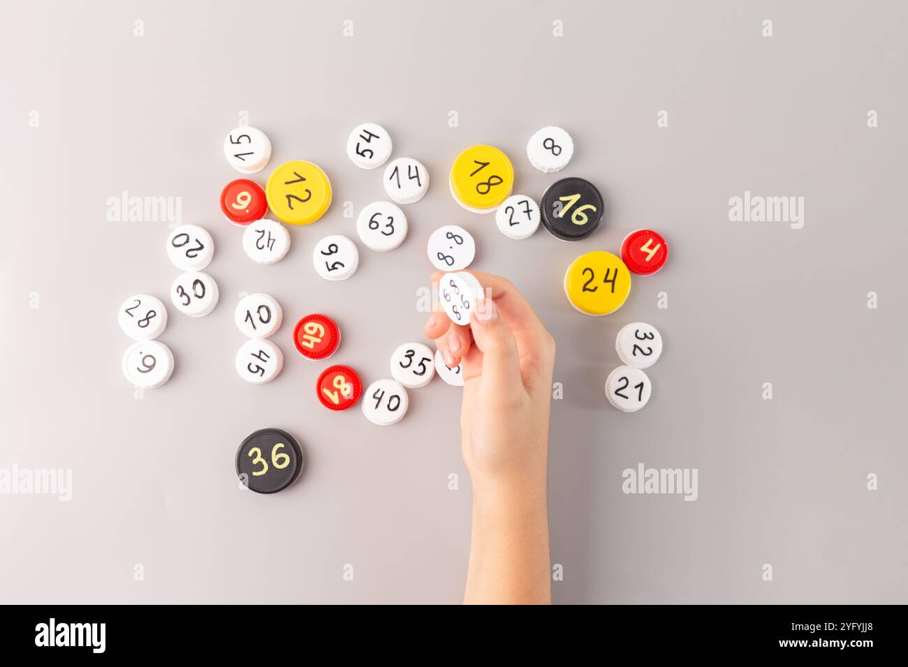 Attività di matematica per bambini con tappi per bottiglie con dati moltiplicativi, pratica pratica di apprendimento pratica, modo divertente per memorizzare i tavoli dei tempi per le elementari Foto Stock