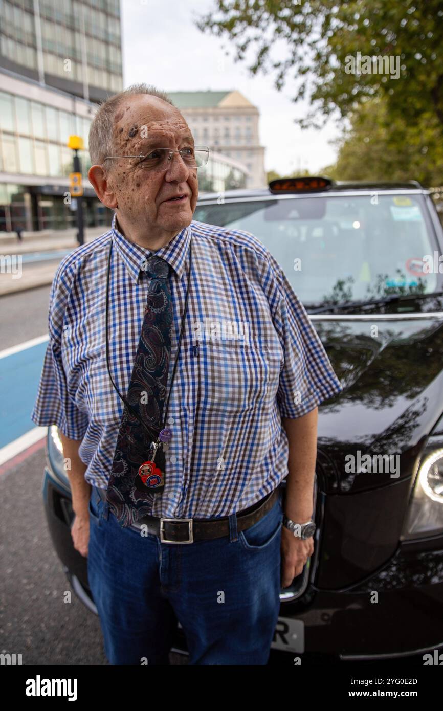 Mike Hughes, il coordinatore indipendente di Poppy Cabs, si trova di fronte a un London taxi. Fondata quindici anni fa dai tassisti di Londra, Poppy Cabs offre viaggi gratuiti per i veterani militari che partecipano all'annuale Remembrance Day Service al Cenotaph di Westminster, Londra. Ispirati al Royal British Legionís Poppy Appeal, dove le spille rosse del papavero vengono scambiate per donazioni di beneficenza, questi tassisti si organizzano sotto l'iniziativa ìPoppy Cabsî. Ogni anno, gli autisti offrono corse gratuite ai veterani delle principali stazioni ferroviarie di Londra, assicurandosi che arrivino Foto Stock