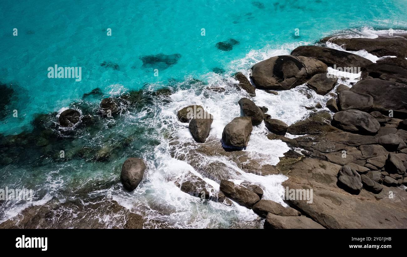 Il mare australiano turchese lambisce la costa rocciosa marrone. Cattura un'altra splendida giornata estiva sulla costa occidentale dell'Australia. Foto Stock