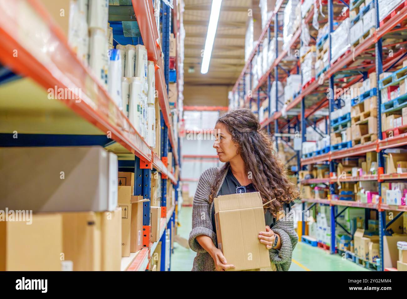 Donna di mezza età rispettosa dell'ambiente che fa acquisti con scatola di cartone per la sostenibilità al supermercato Foto Stock