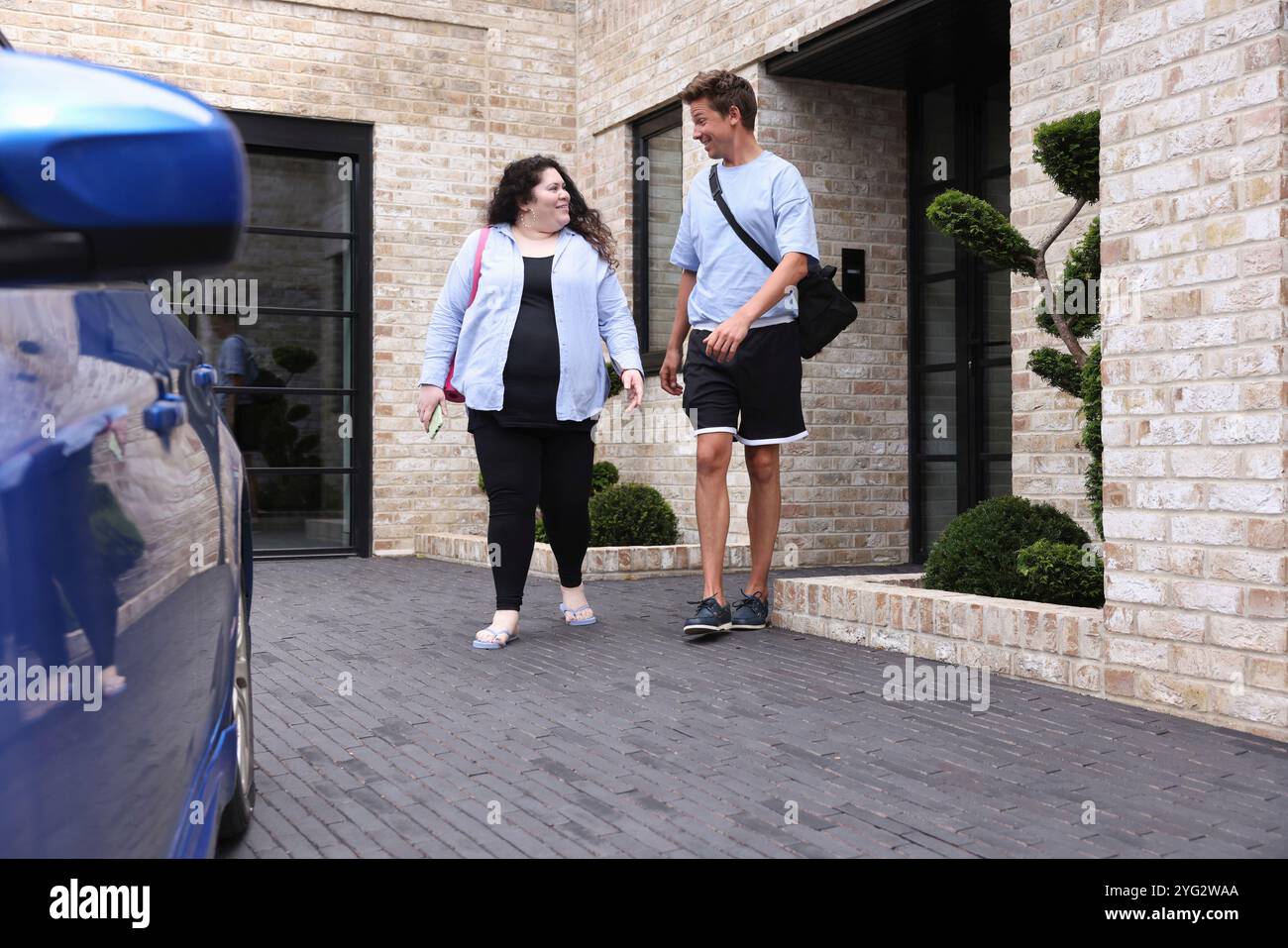 Uomo e donna che parlano e escono dall'edificio Foto Stock