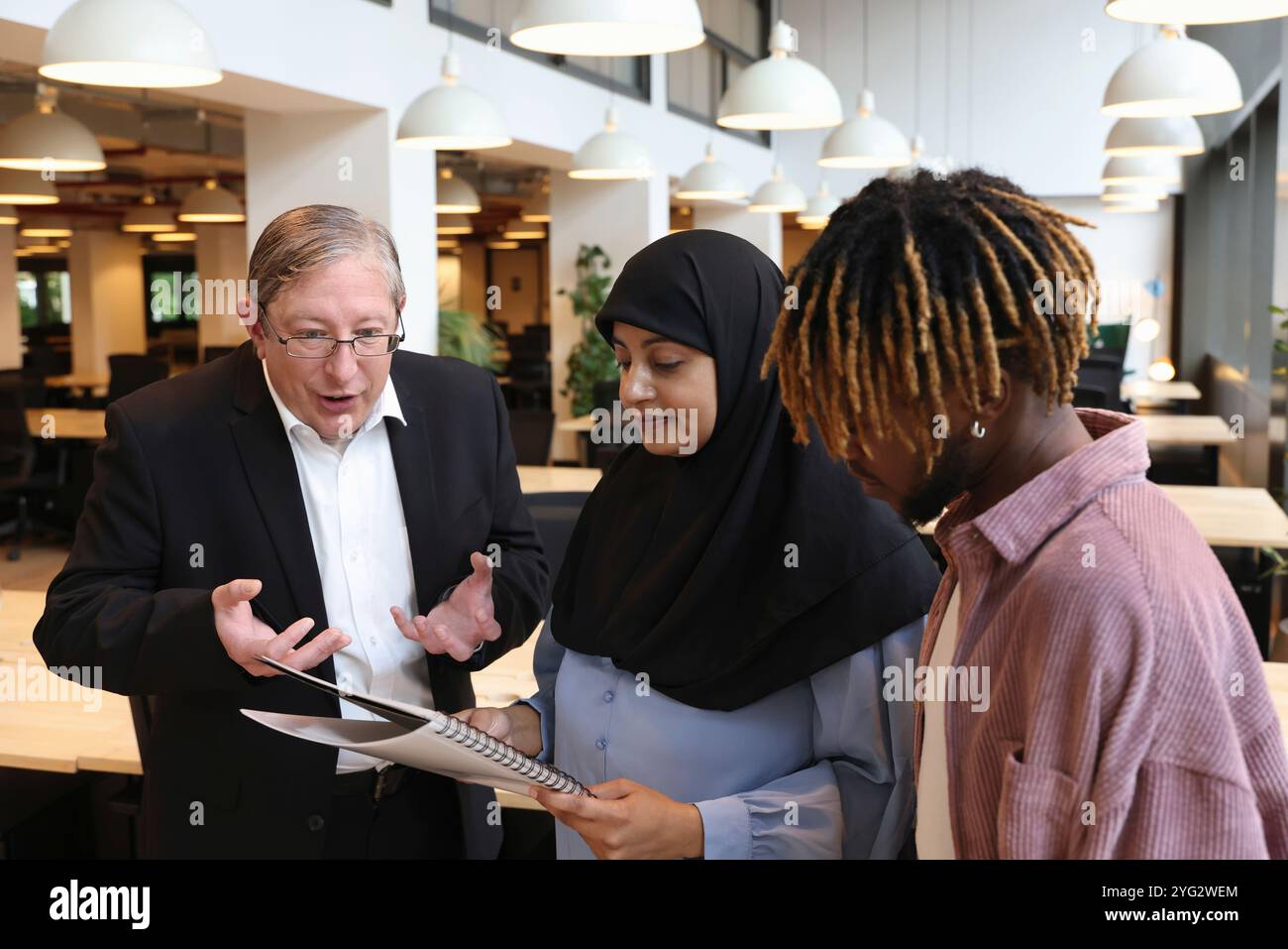 Due uomini d'affari e una donna d'affari che discutono in ufficio Foto Stock