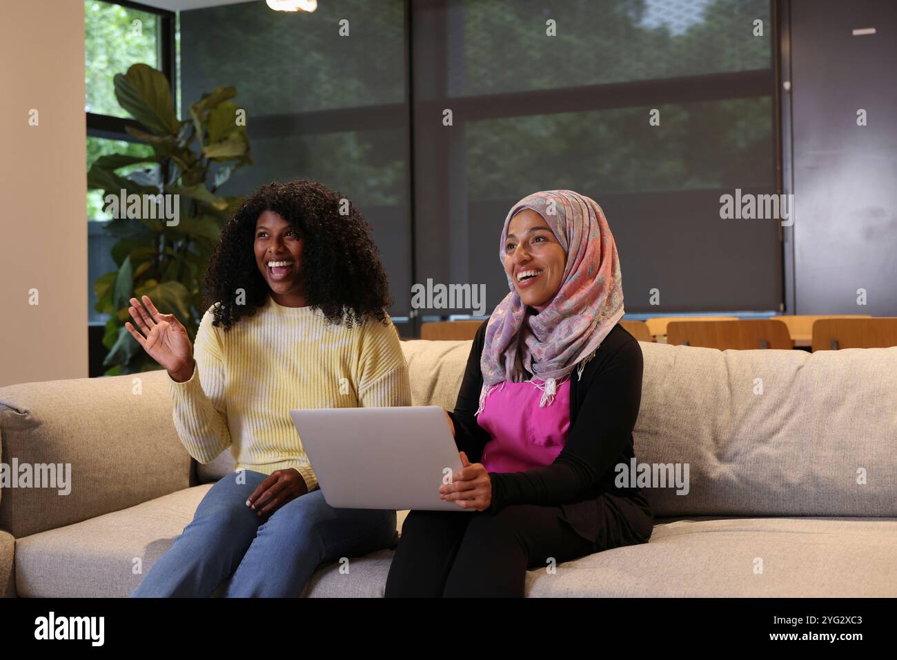 Donne sedute su un divano in un ufficio moderno Foto Stock