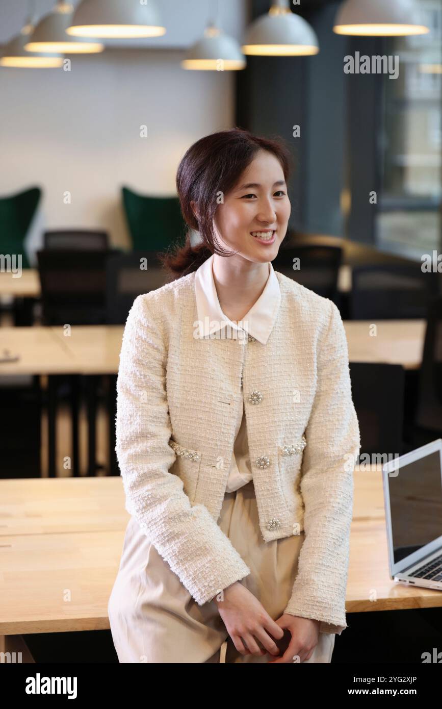 Donna sorridente in ufficio Foto Stock