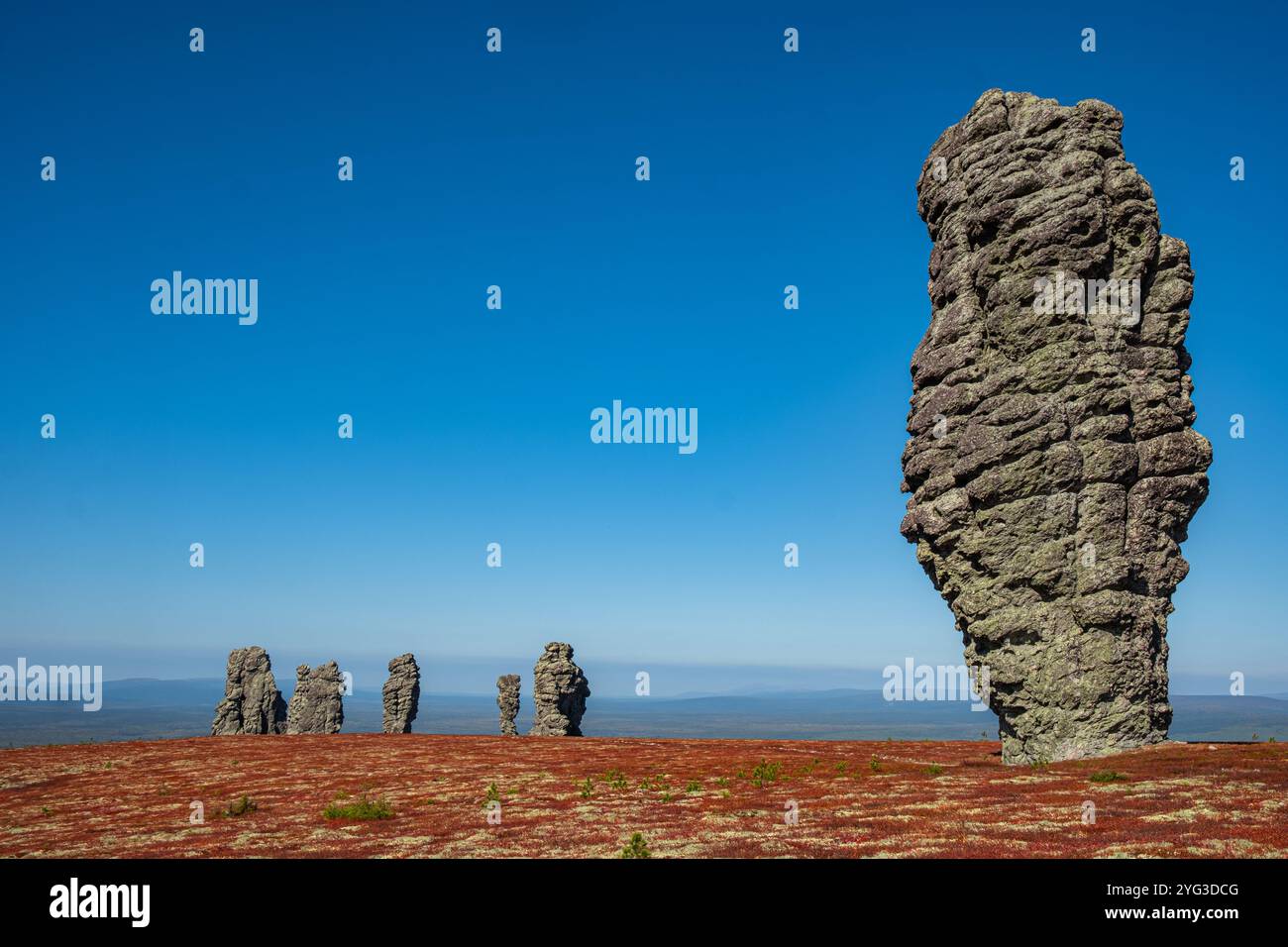 Splendida vista delle formazioni rocciose di manpupuner in russia, alte su tundra rossa sotto un vivace cielo blu, un luogo popolare per avventurieri e fotografi Foto Stock