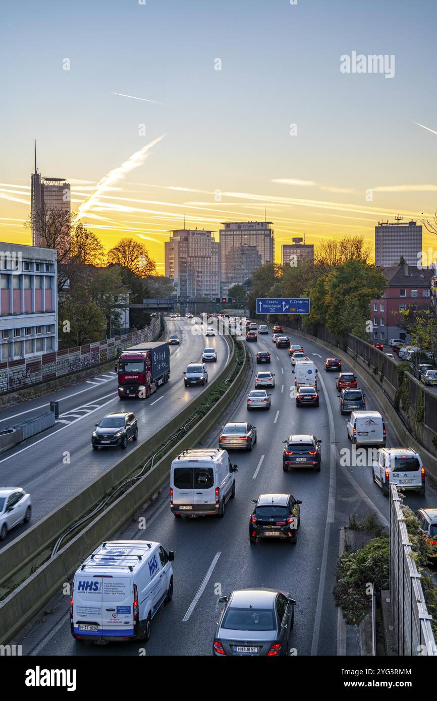 Traffico serale, in parte con ingorghi, traffico lento sull'autostrada A40, skyline di Essen, torre RWE sulla sinistra, sede del gruppo Evonik Foto Stock